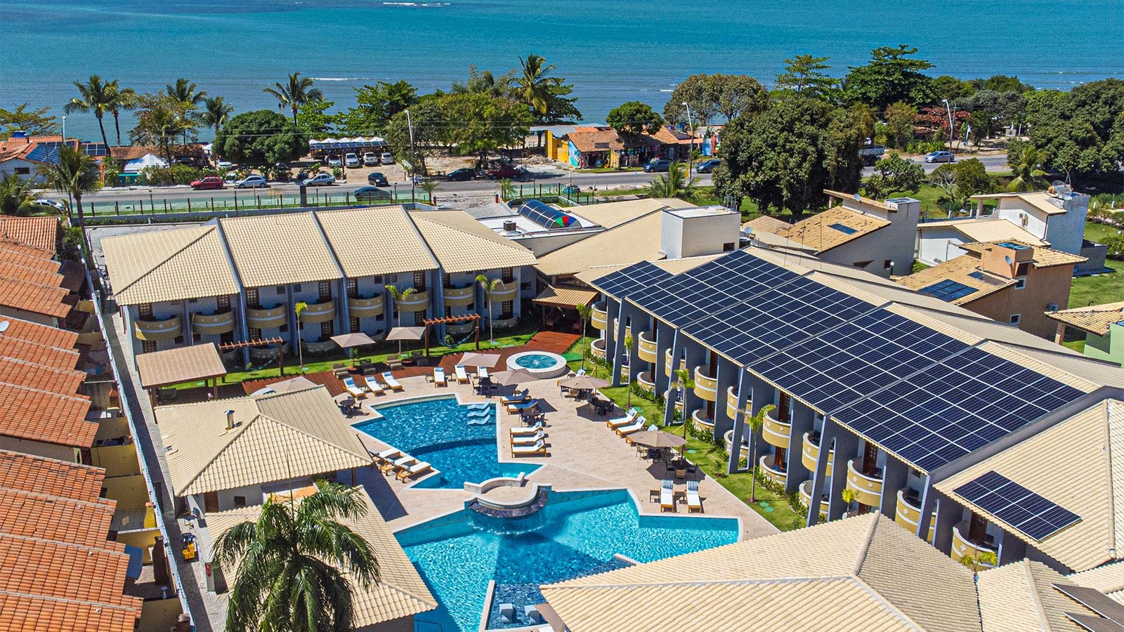 Vista aérea do hotel com placas de energia solar e área verde