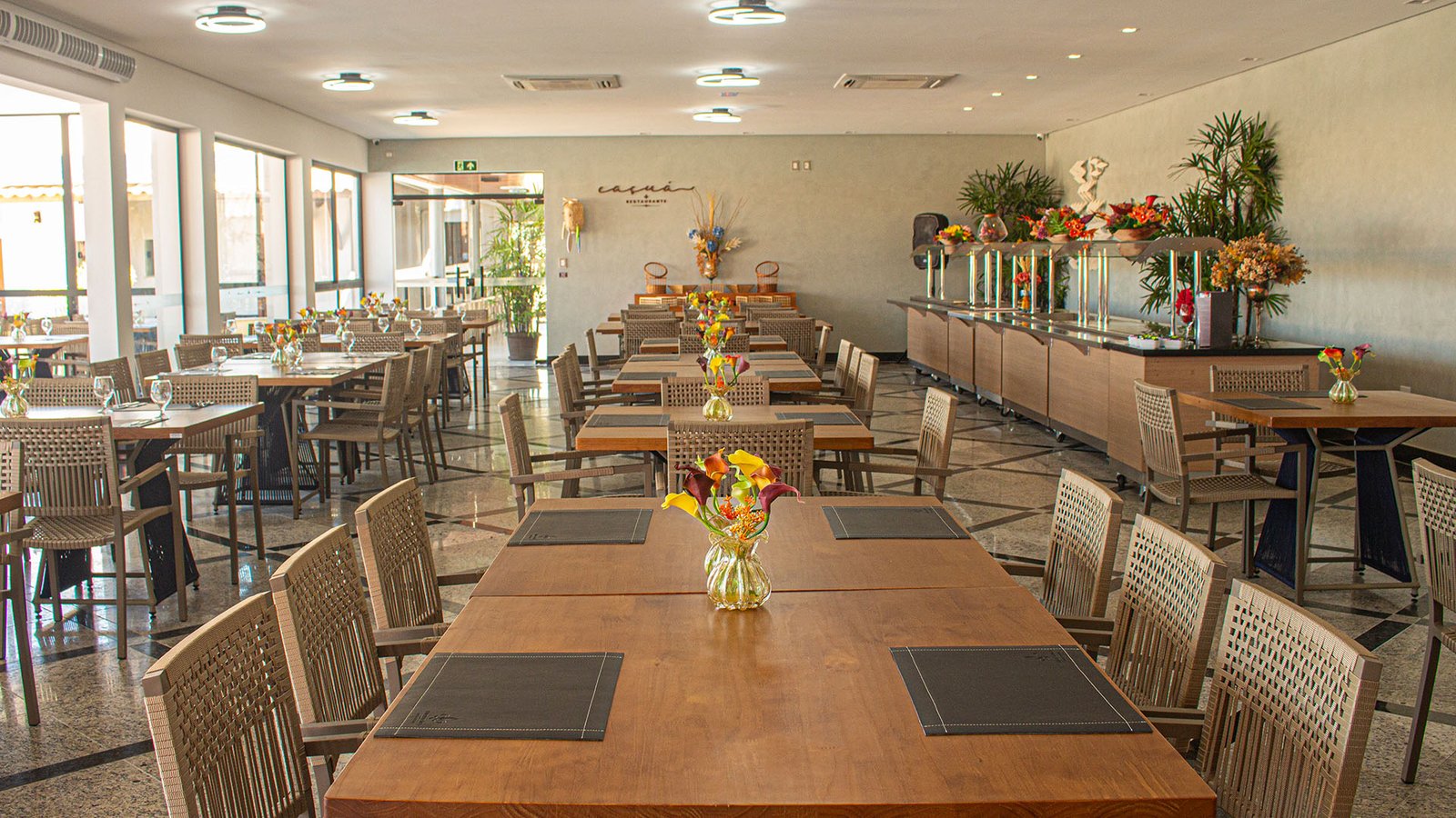 Salão do Caçuá com taças de vinho e arranjos de flores